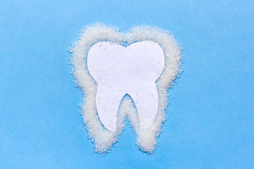 White tooth shape surrounded by fluffy clouds on blue background, dental care concept
